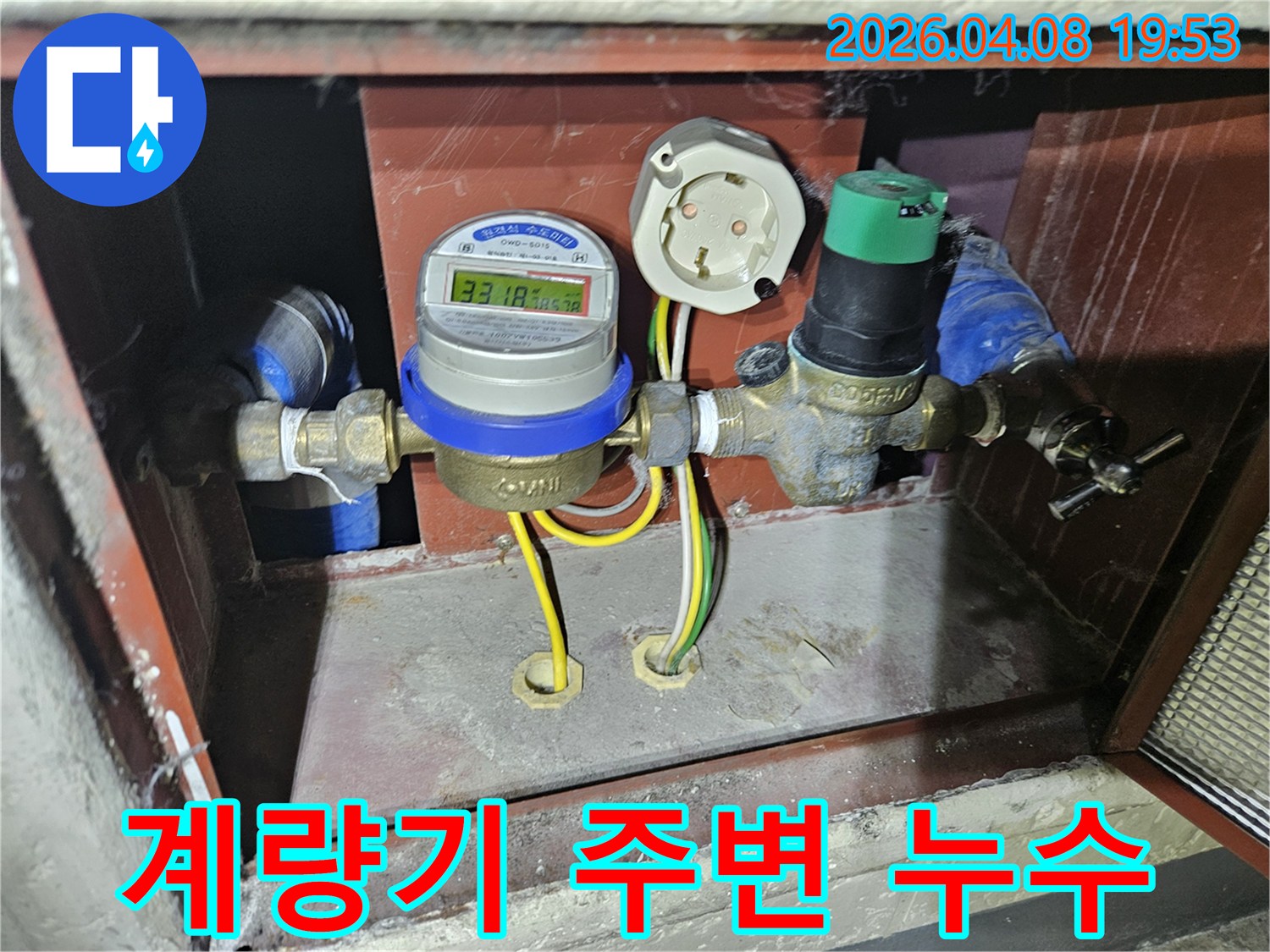 주택의 수도 공급 라인에 설치된-디지털 수도계량기와 압력 조절 밸브의-정밀한 설치 상태를 보여주는 사진입니다.