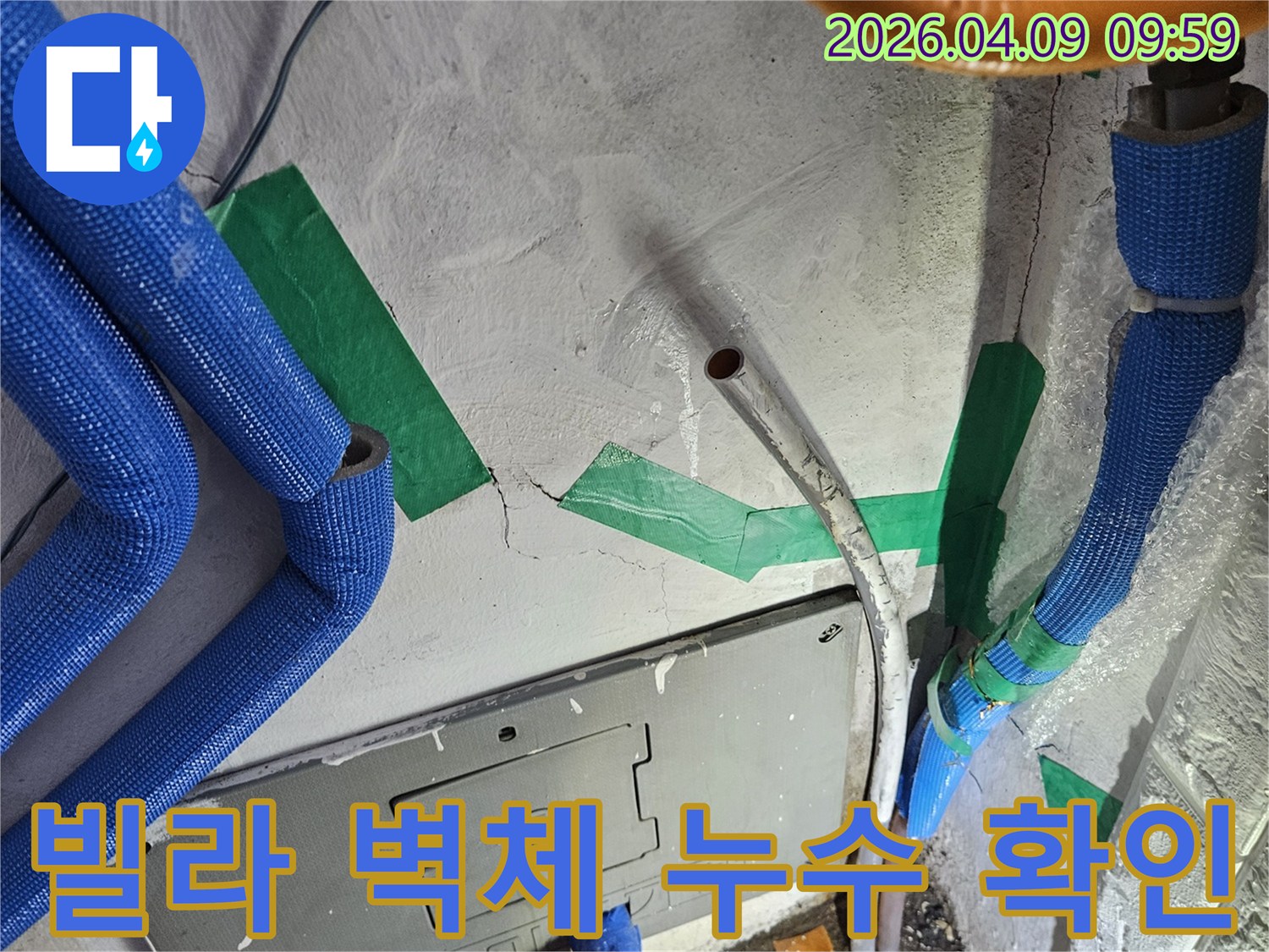 콘크리트 벽면의-미세한 균열을 따라-물이 새어 나온 흔적과-다양한 색상의-배관들이 노출된-누수 발생 지점