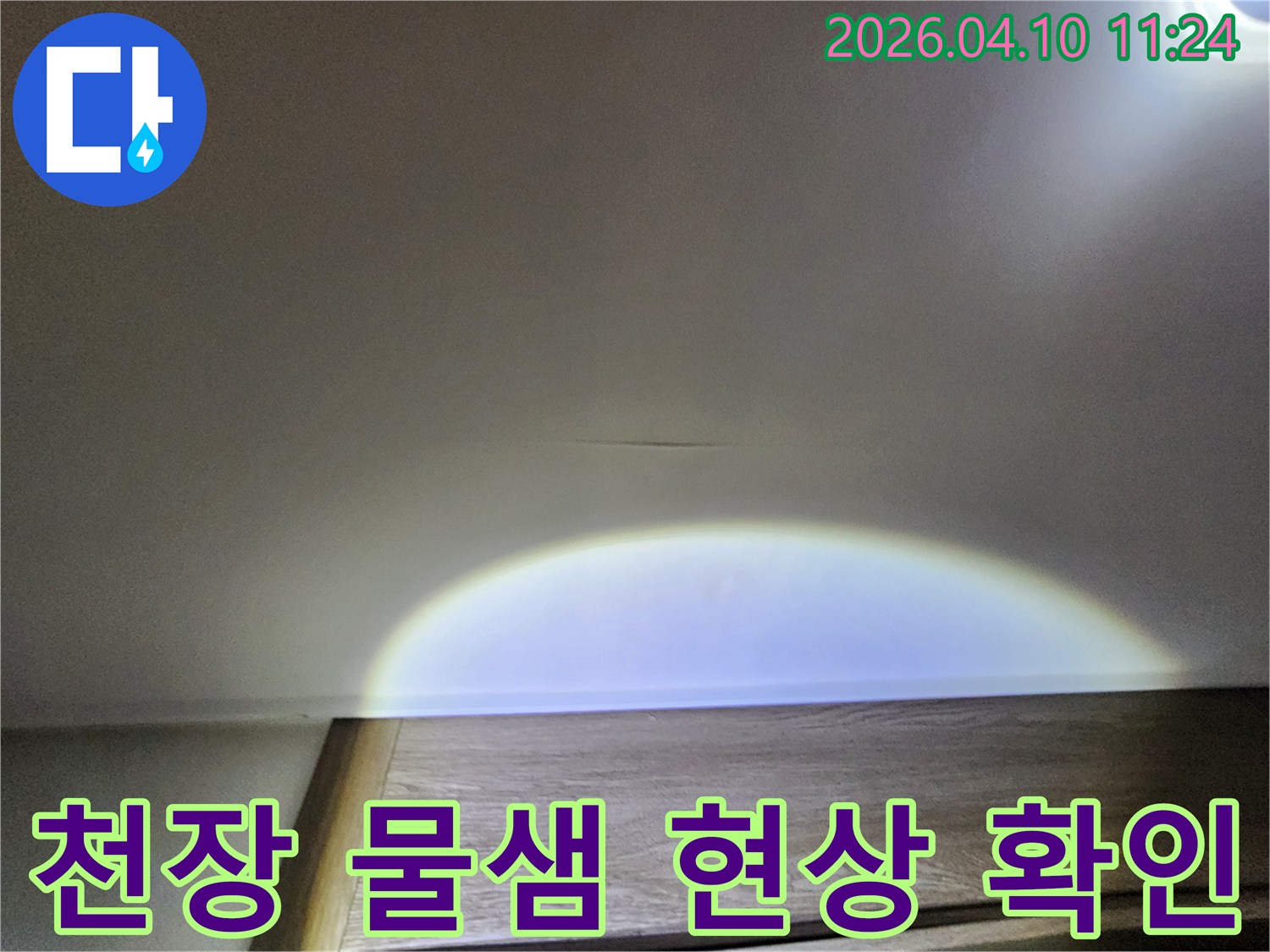 천장-표면에-나타난-미세한-물샘-흔적을-손전등으로-밝혀-자세히-살펴보는-사진