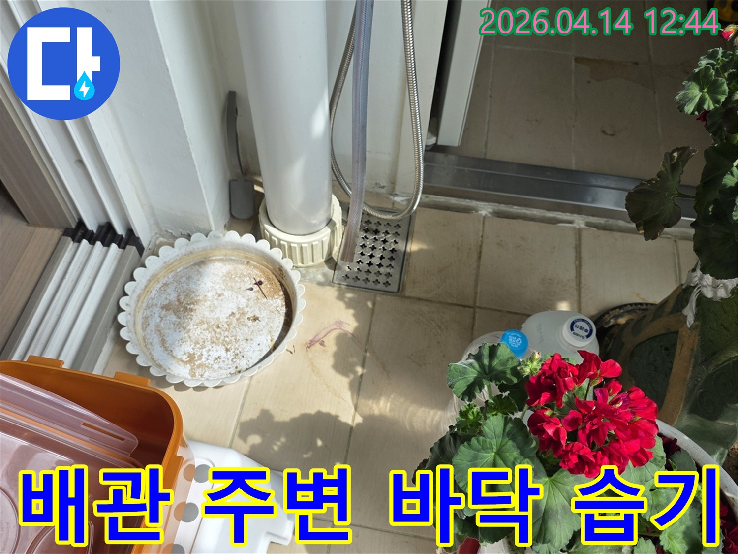 이 이미지는-풍무동 아파트 베란다의-배관 주변 바닥에서-발견된 습기 문제를-보여주는 현장 사진입니다