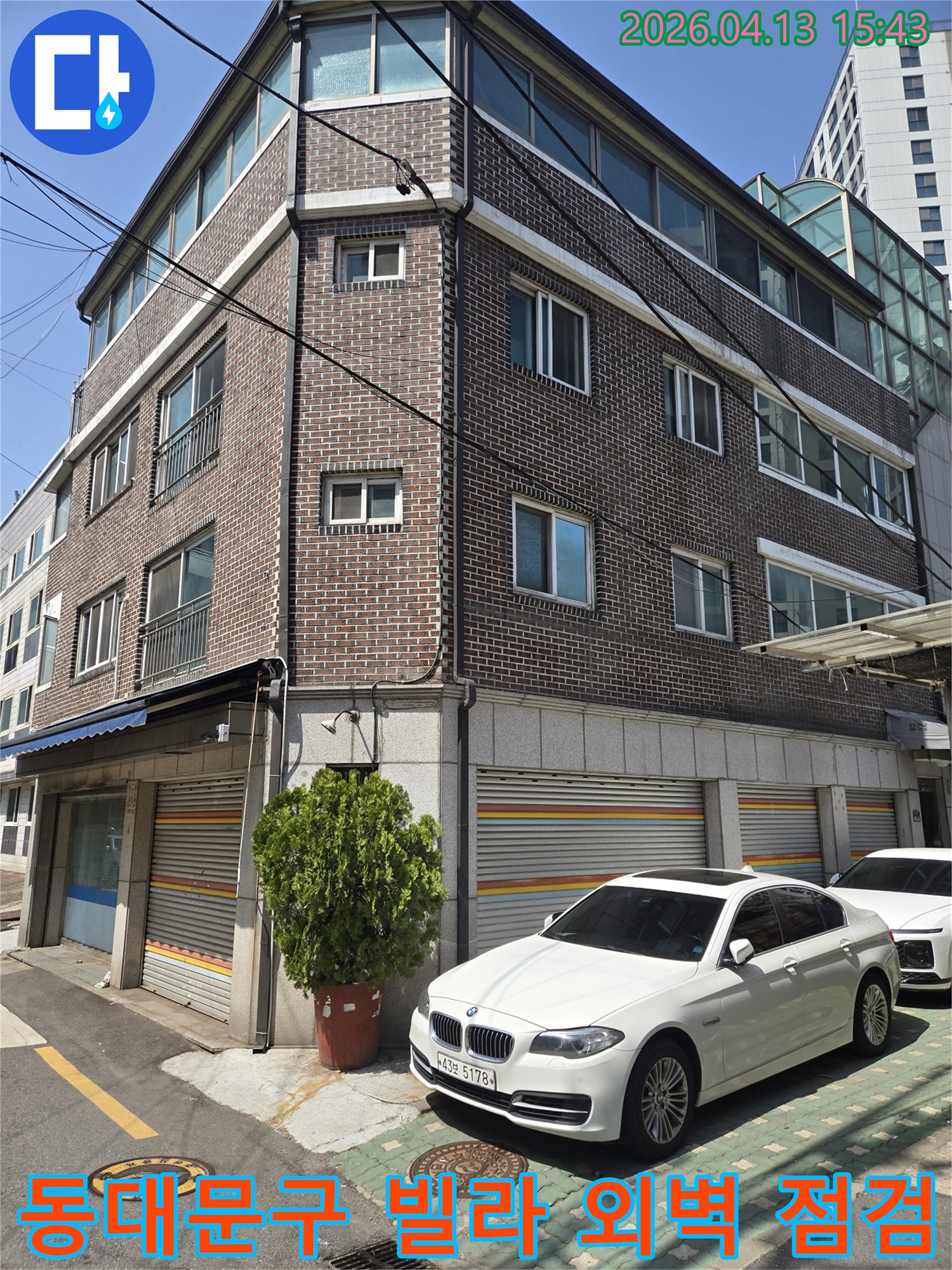 이 이미지는-서울 동대문구에 위치한-벽돌 건물 외관을-보여주며-누수 원인을-파악하기 위한-초기 현장-조사 과정을-담고 있습니다