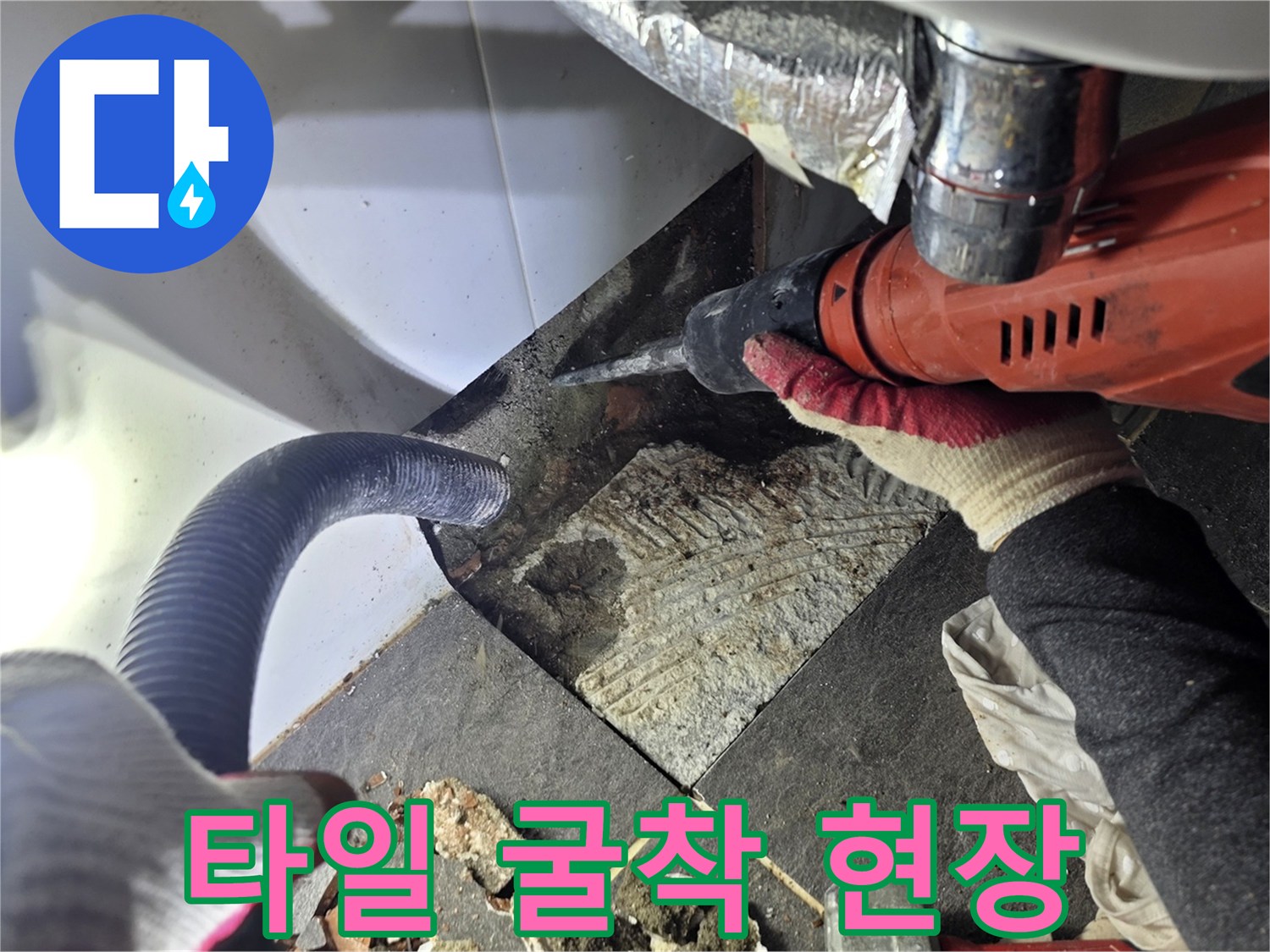 전동 공구를 사용하여 바닥 타일을 절개하고 배관 노출 작업을 진행함