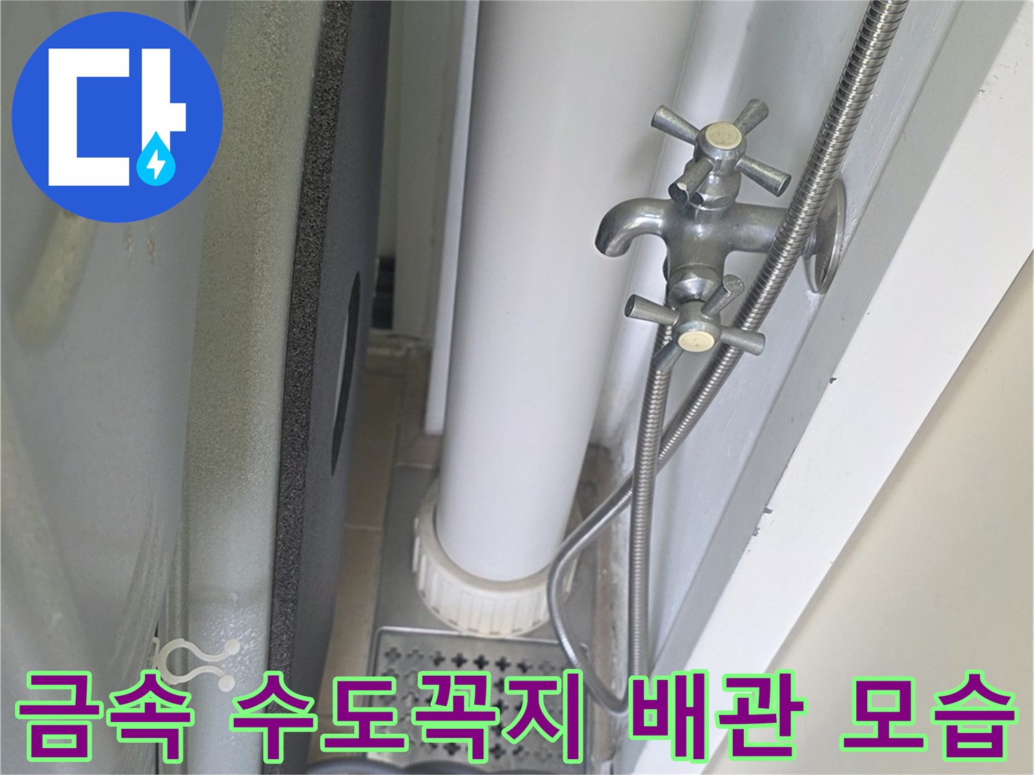 벽면 타일 부근에 설치된 은색 수전과 연결된 유연한 호스