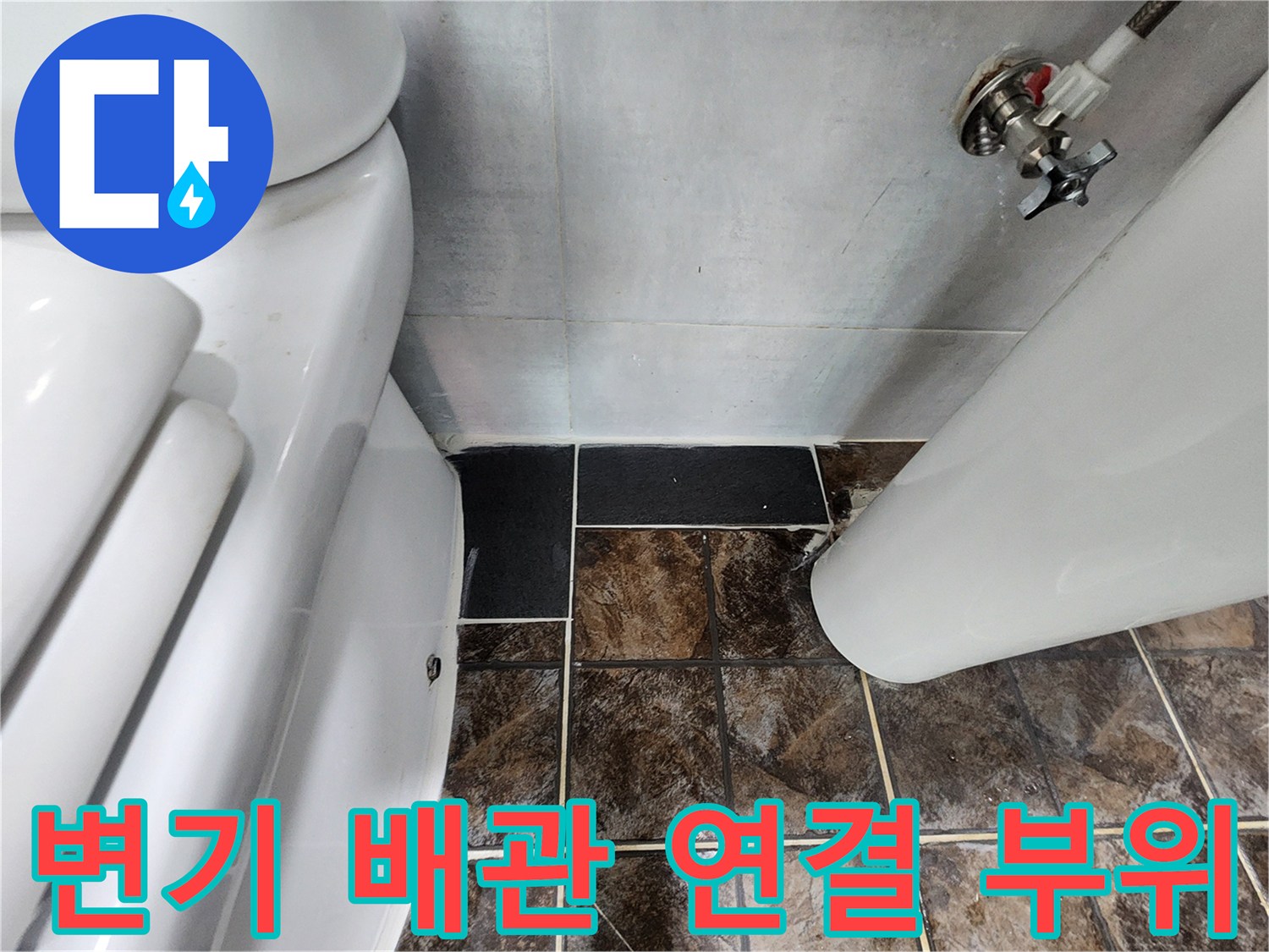변기 옆 벽면 타일에 설치된 수도꼭지와 배관의 근접 촬영본입니다.