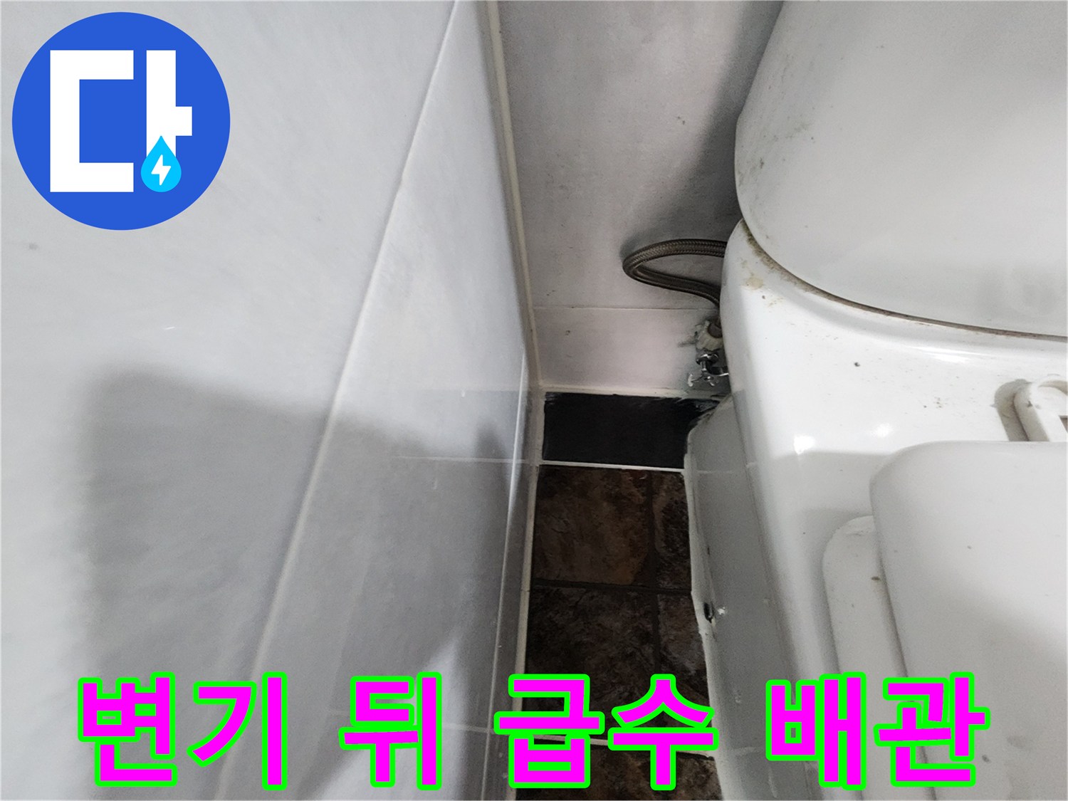 하얀색 변기와 벽면 타일 사이의 배관 연결 부위