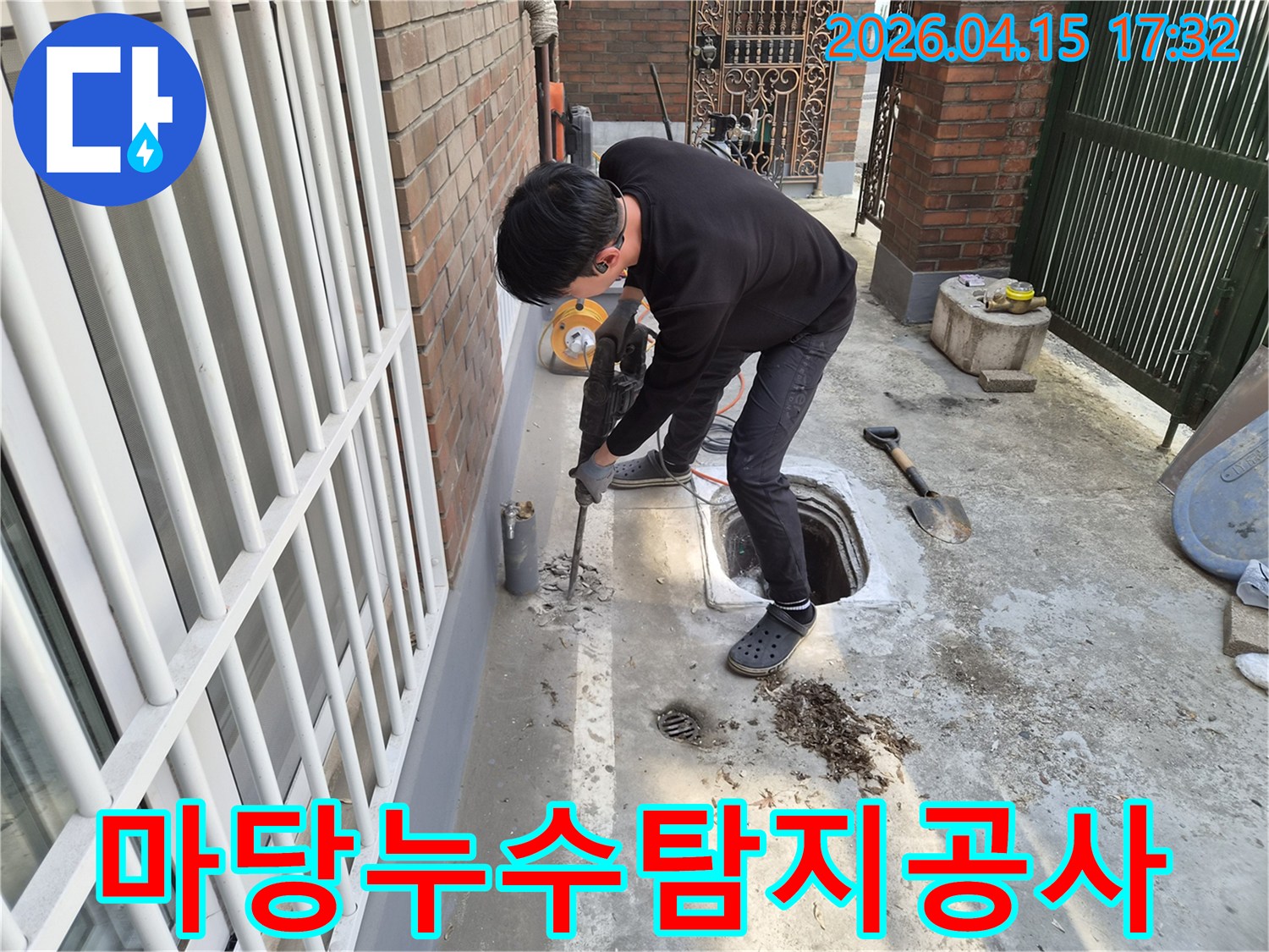 성동구 주택의 마당에서-누수 지점을 발견하고-파쇄 장비로 바닥을 깨는 작업이 진행 중입니다
