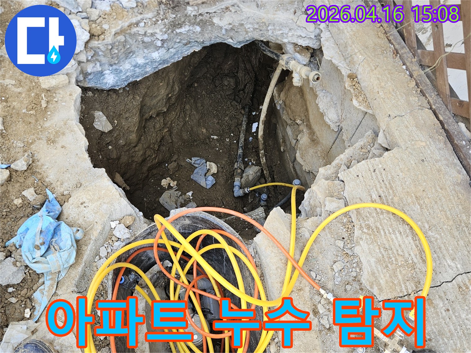 아파트 내부 배관에서 발생한 누수 지점을 찾아내기 위해-바닥을 개방하고 전문 압력 테스트 장비를 설치하여-정밀하게 진단하는 작업 현장입니다.