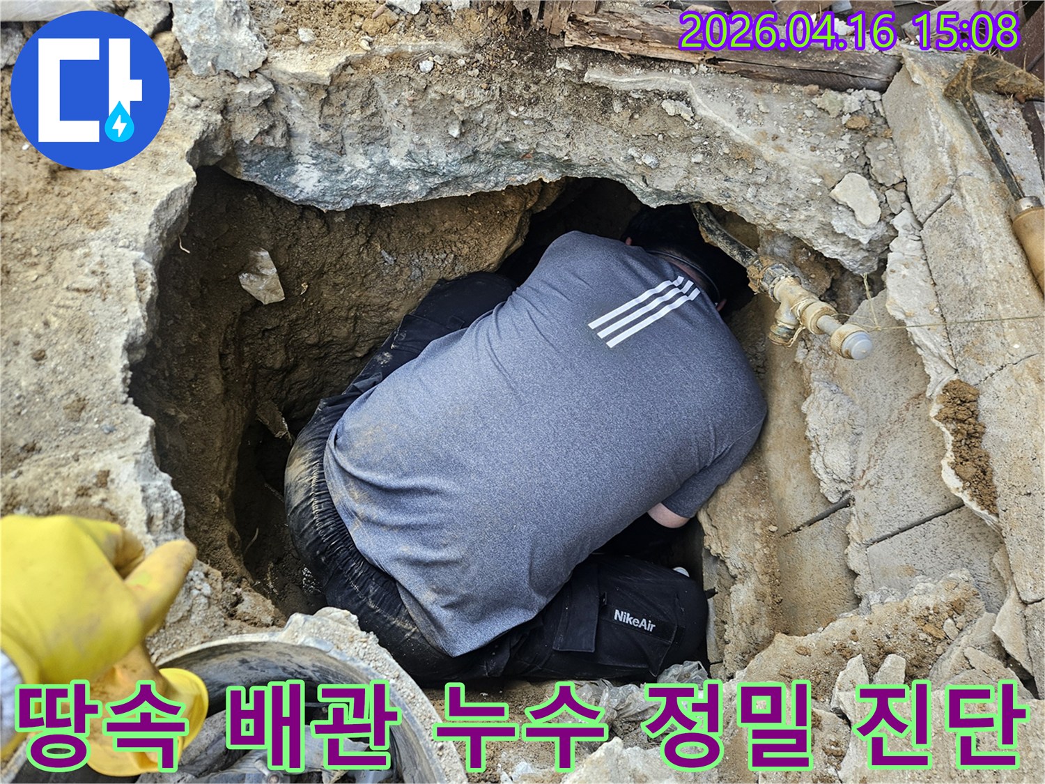 전문 누수 엔지니어가-땅속에 묻힌 배관의-누수 지점을 정확히 파악하기 위해-좁은 공간에서 집중하는 모습