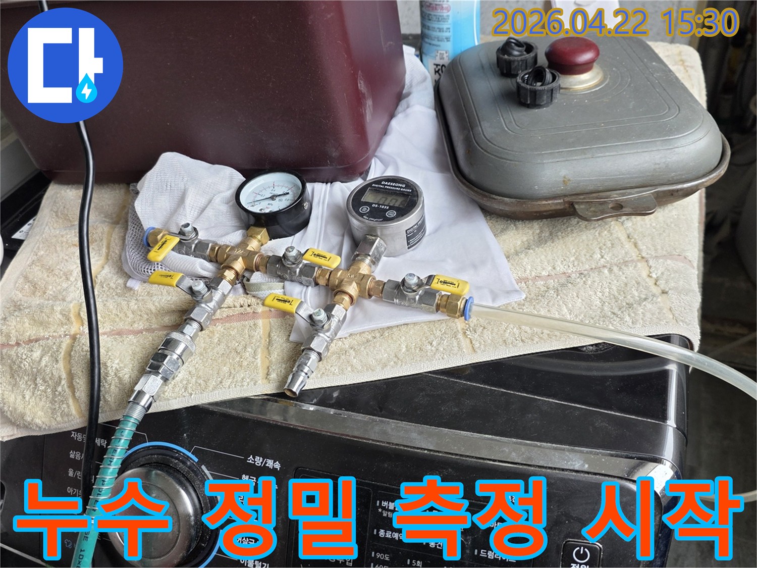 누수 지점을 정확히 찾아내기 위해-압력 게이지와 유량계가 연결된-전문 장비를 통해-정밀 측정을 시작하는 장면입니다.