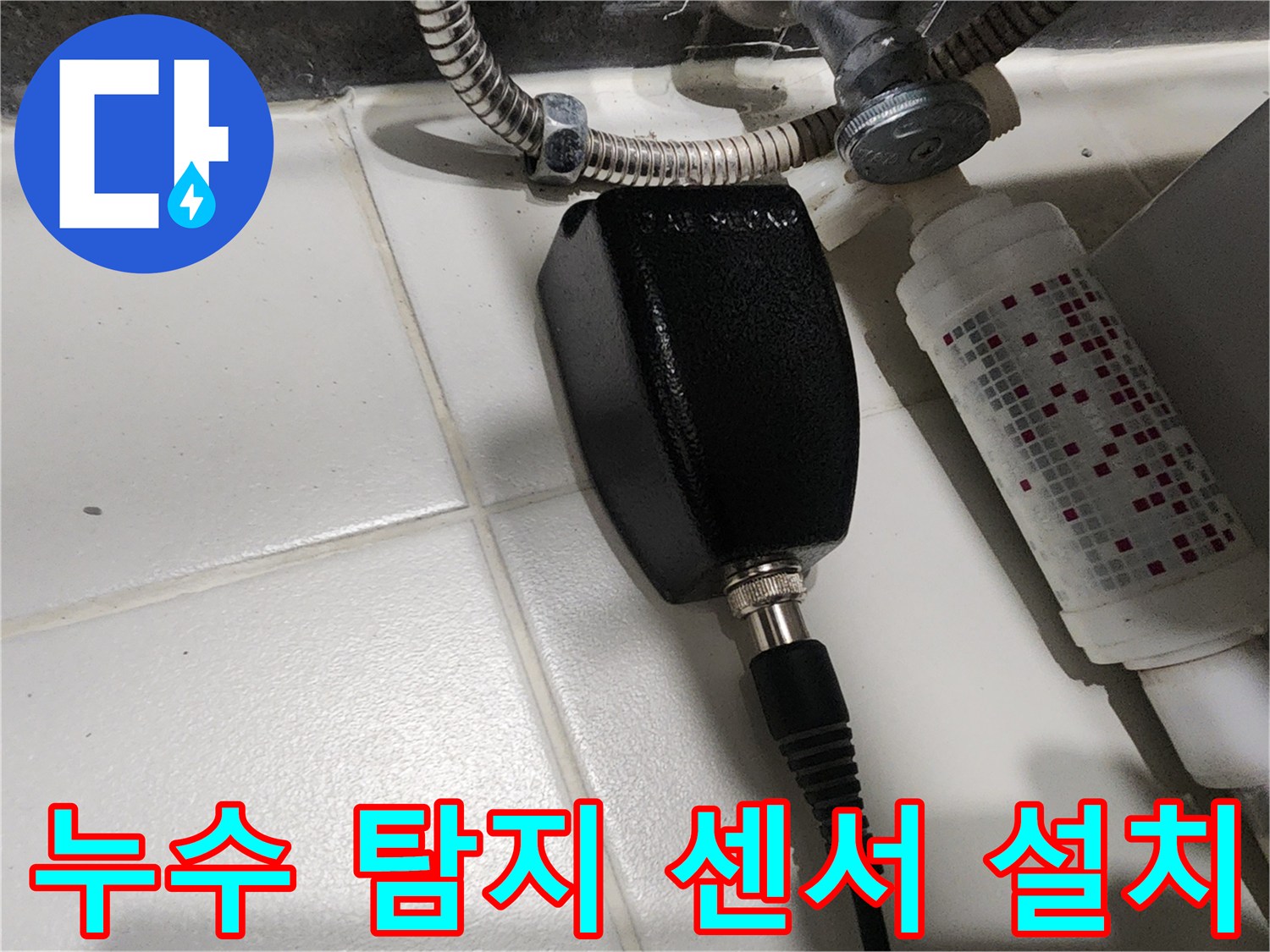 배관 근처에 배치된-검은색 청음식 센서와-연결 케이블의 상세 모습입니다.