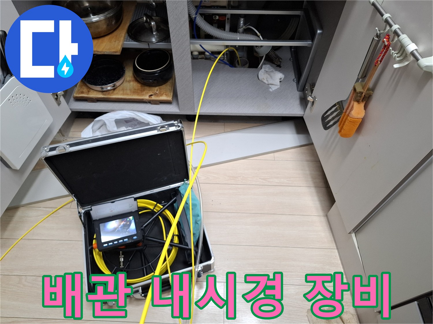 싱크대 하부장 밑-내시경 화면과 연결된 노란색 배관 검사 케이블