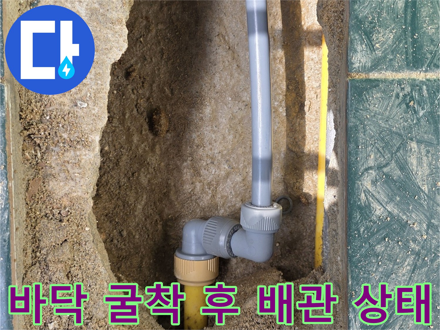 타일 아래 매립된 노란색 배관과 교체용 부속의 연결 모습