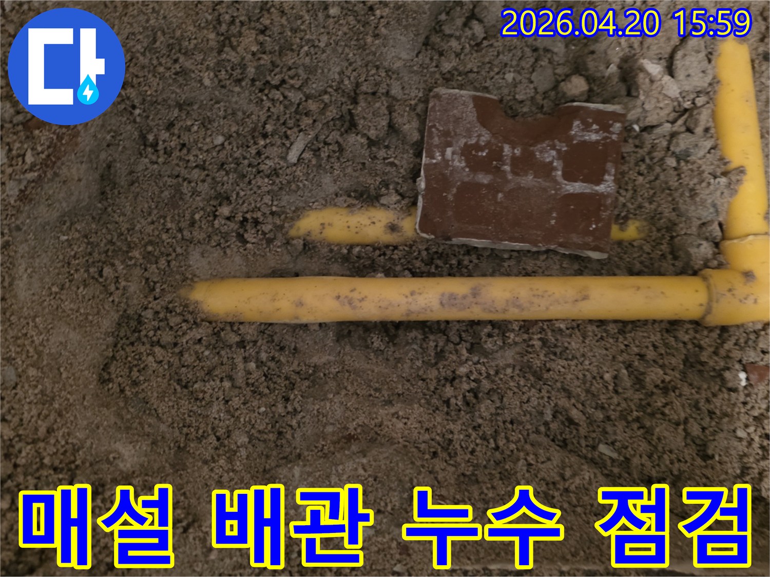 흙 속에 묻힌 노란색 배관에서-누수 지점을 찾아 점검하고 수리하는 현장입니다