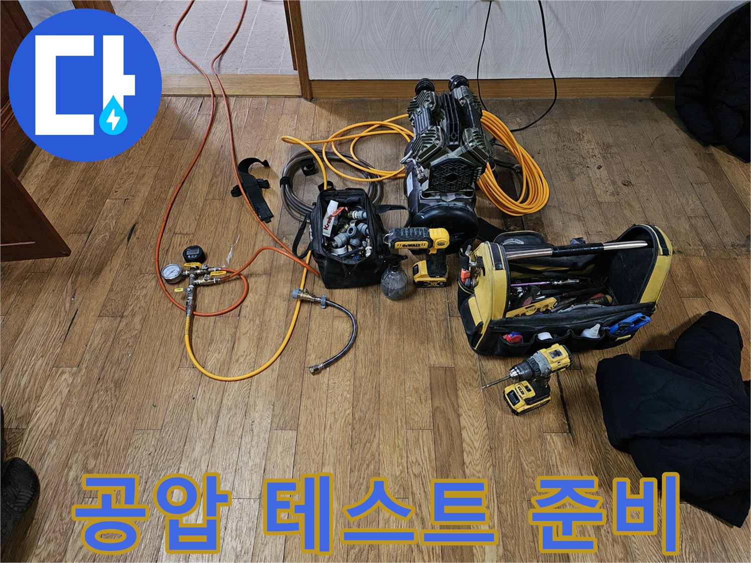 누수-해결을-위해-공압-테스트-장비와-다양한-배관-공구들이-바닥에-정돈되어-있습니다