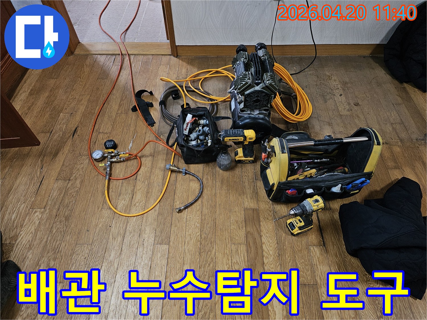용인 기흥구 아파트 온수배관 누수 탐지를 위해-정밀 공압 탐지 장비와-다양한 공구들이 바닥에 준비된 모습