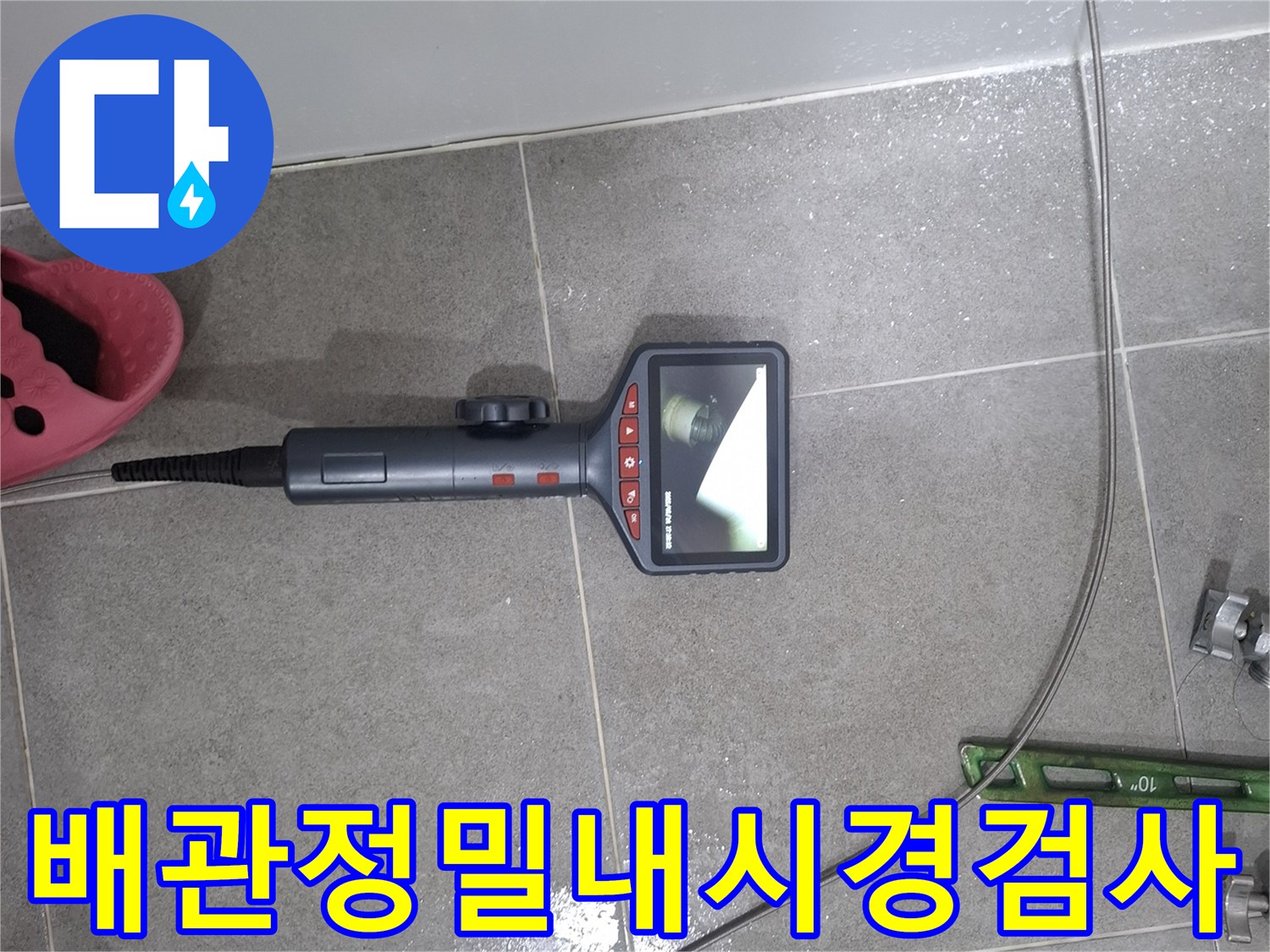 누수 탐지 전문가가 욕실 배관 내부의 상태를 정밀하게 확인하기 위해-내시경 카메라를 삽입하여-모니터로 실시간 관찰하는 모습
