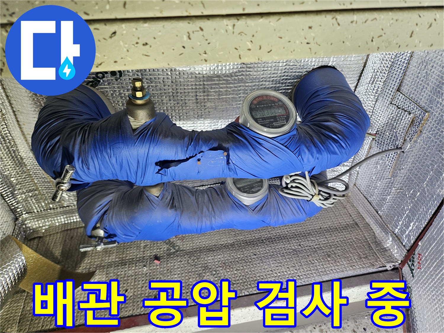 파란색 보온재가 씌워진 배관과 디지털 압력계 상세 촬영