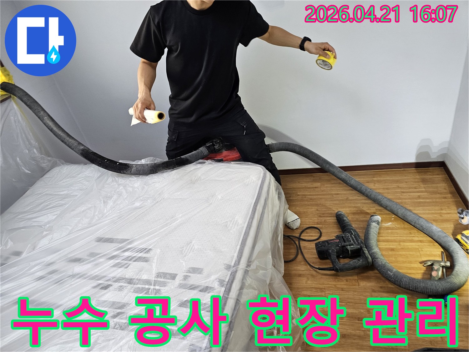 누수 공사 현장에서-고객의 불편을 최소화하고-깔끔한 마무리를 위해-분진 흡입 장비와-보양재를 사용하는-전문 엔지니어의 모습