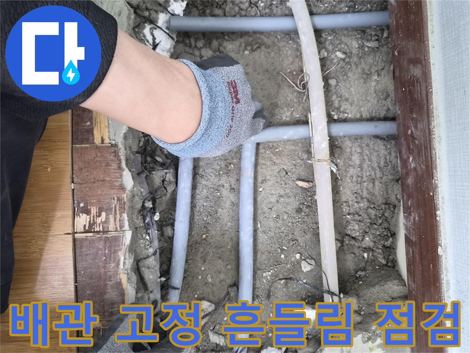 누수 전문가가 노출된 배관의-고정 상태와 흔들림 여부를-점검하는 신중한 모습입니다
