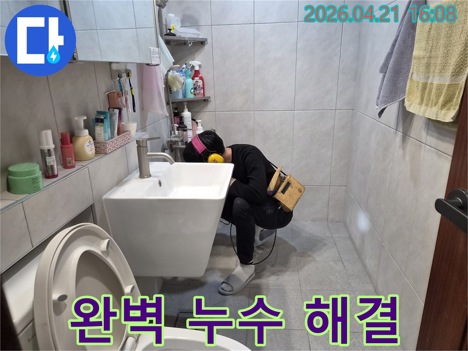 전문 엔지니어가 욕실에서-청음 장비를 이용해-배관에서 발생하는 미세한 누수음을 듣고-완벽하게 누수 지점을 찾아내고 있습니다