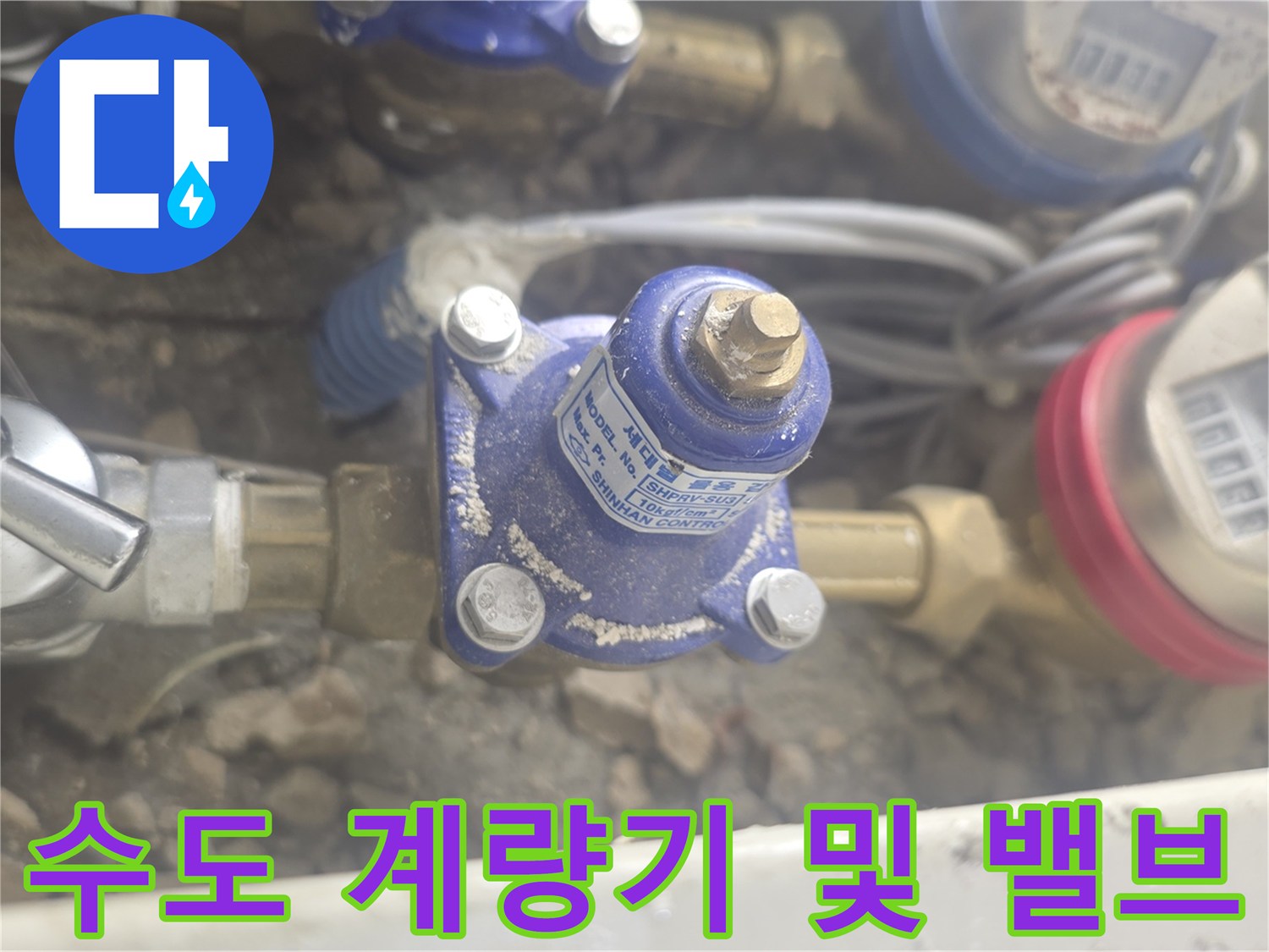 흙과 자갈 사이에 위치한 수도 계량기 장치 사진