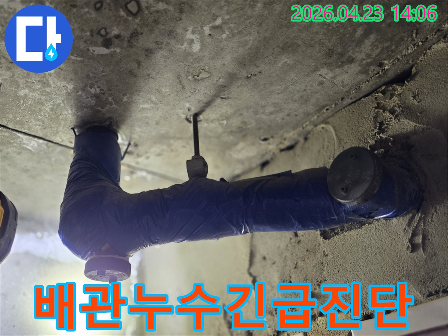 보온재로 감싸진 배관 아래-천장 콘크리트가 젖어있는-누수 현장의 클로즈업 사진-물방울이 맺혀있는-문제 지점-긴급 진단이 필요한 상황