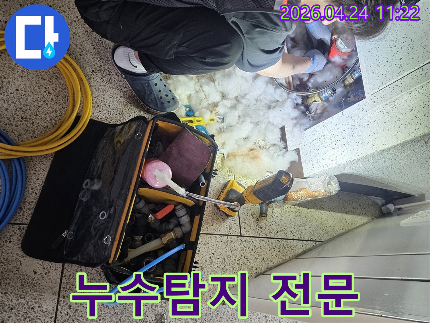 누수-탐지-전문가가-공압-검사를-위해-배관에-장비를-연결하는-모습