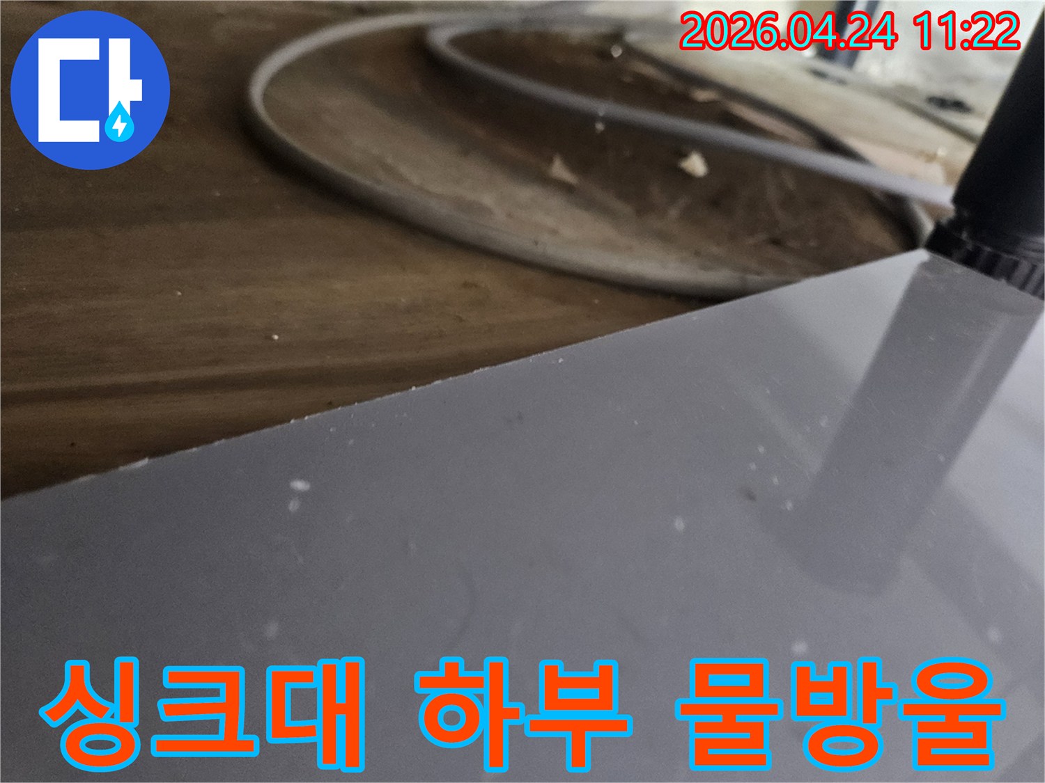 싱크대-하부-장-안쪽에서-발견된-물-고임-현상-누수-징후를-정밀하게-확인하는-모습