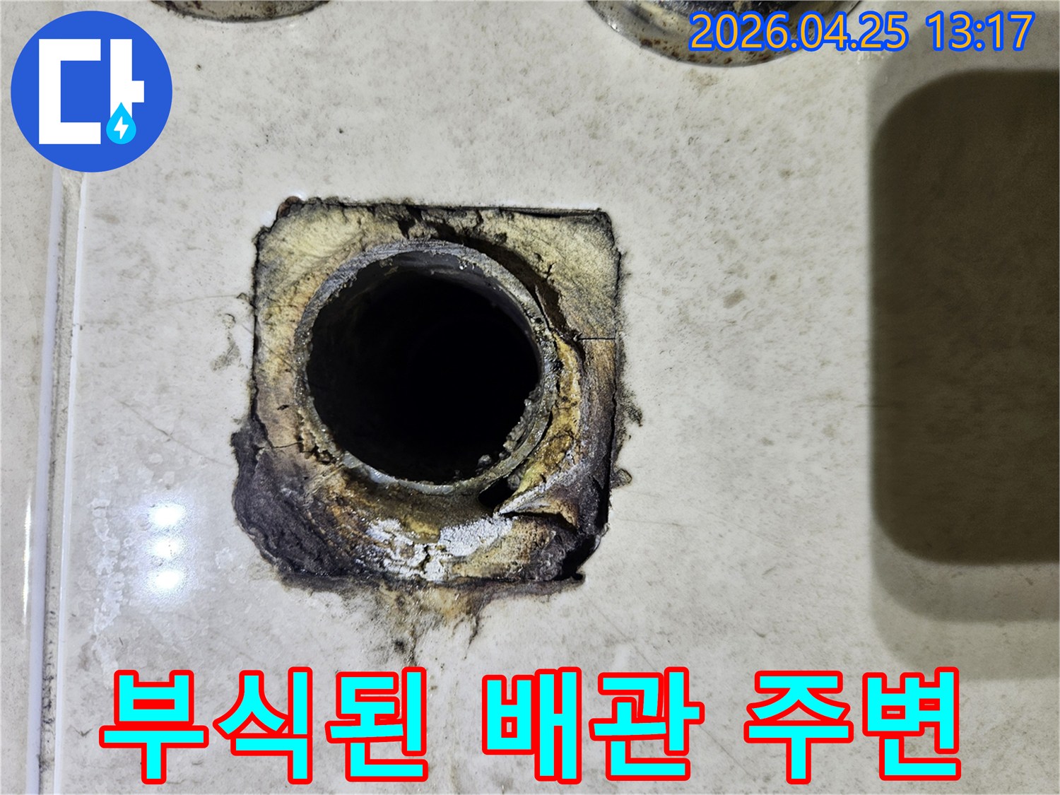 누수로 인해 부식되고 훼손된 배관 주변의 마감재를 보여주는 현장 사진입니다-정확한 진단이 필수적입니다