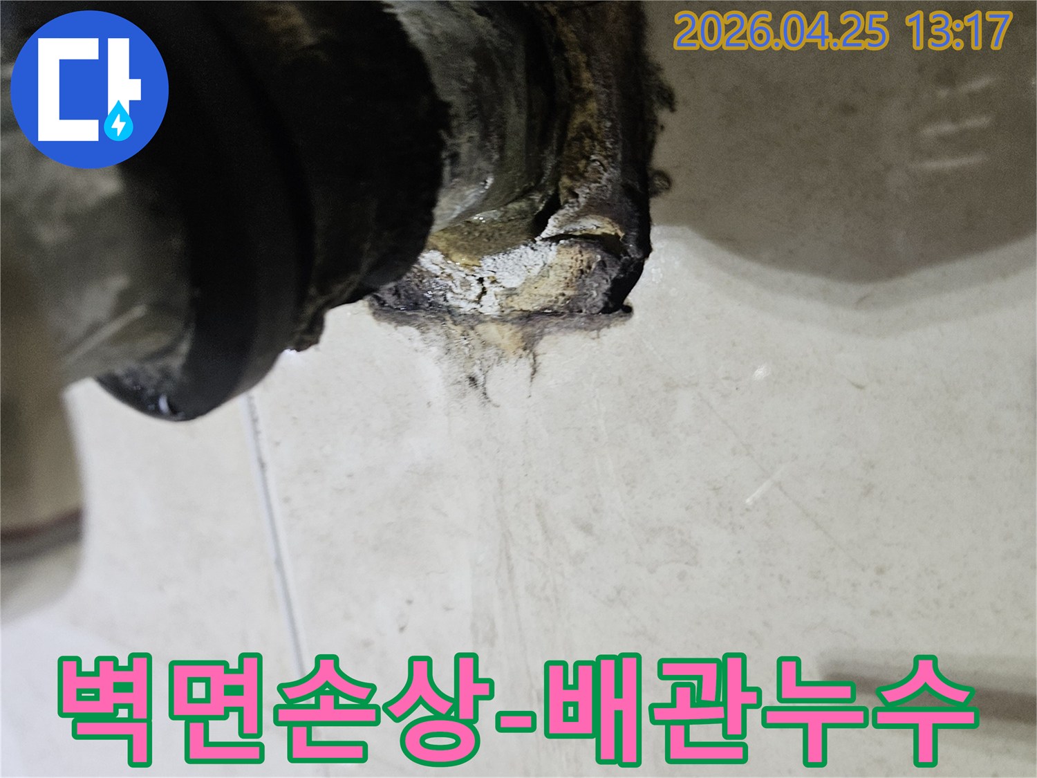배관 연결부에서 발생한 누수로 인해 벽면이 심하게 손상되고 오염된 상태를 보여주는 사진입니다-즉각적인 누수 공사가 필요합니다.
