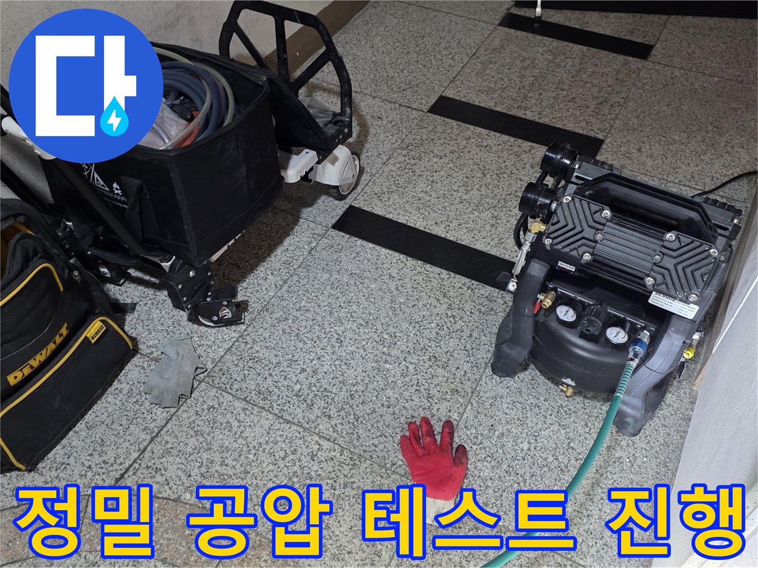 바닥 타일 위에 놓인 가스 탐지용 콤프레샤와 작업 도구 세트