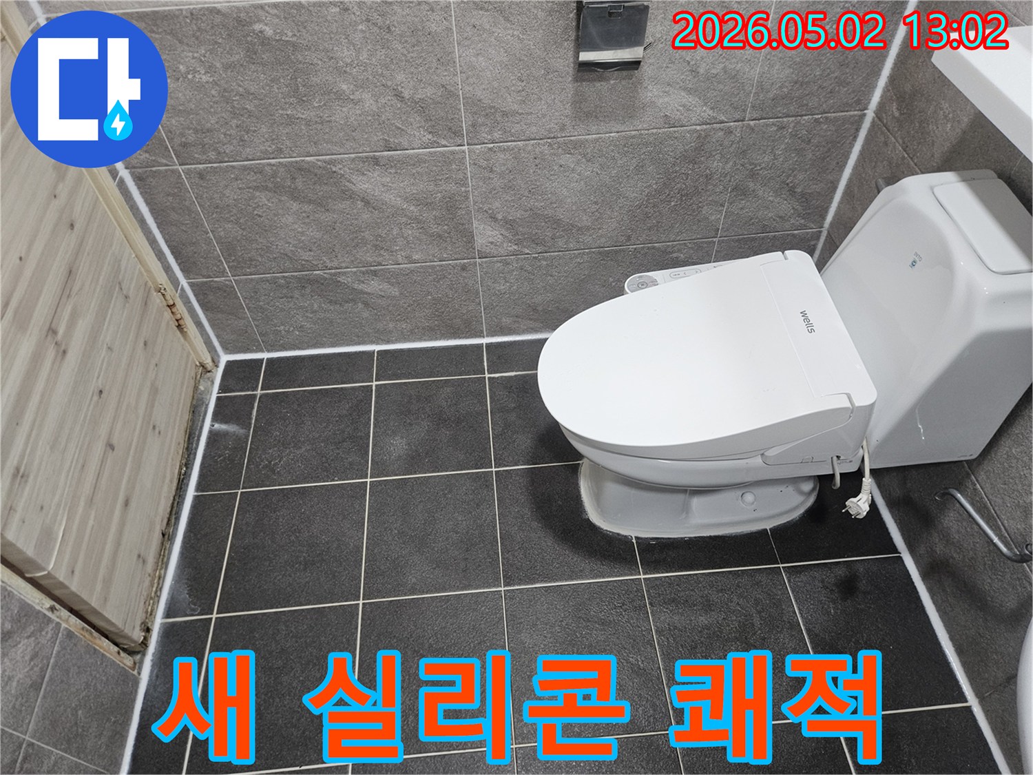 이 사진은 욕실의 변기 주변과 바닥-벽 타일 이음새에 새로 시공된 깨끗한 실리콘 코킹 마감 상태를 보여줍니다.