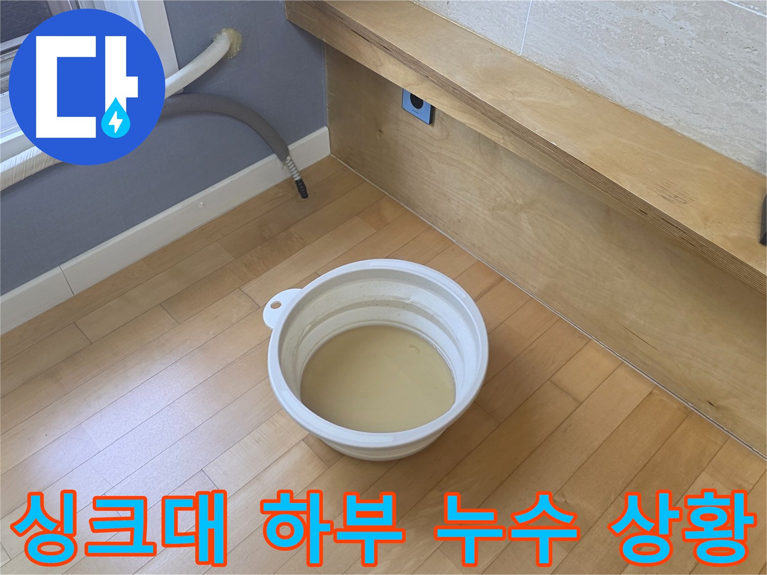 배수-호스-밑으로-새어 나온-물을-버킷에-받아낸-장면