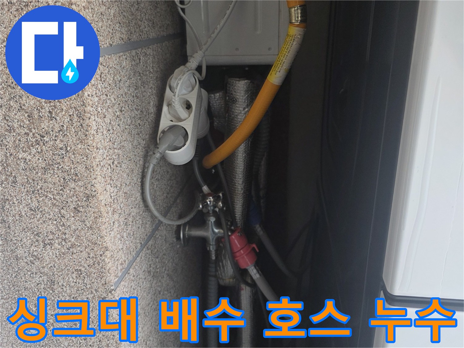 싱크대 아래쪽 노란색 호스와 금속 연결 부위의 습기를 보여주는 사진입니다