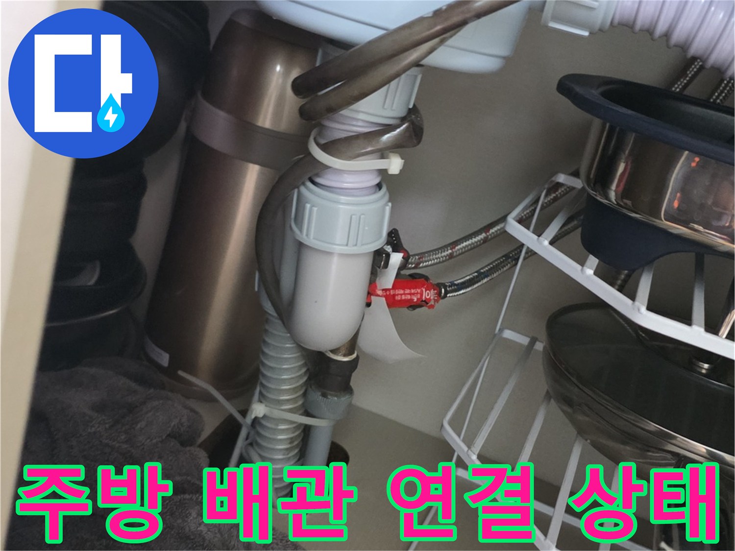 싱크대 아래쪽 배수 호스와 굵은 배관의 연결 모습입니다.