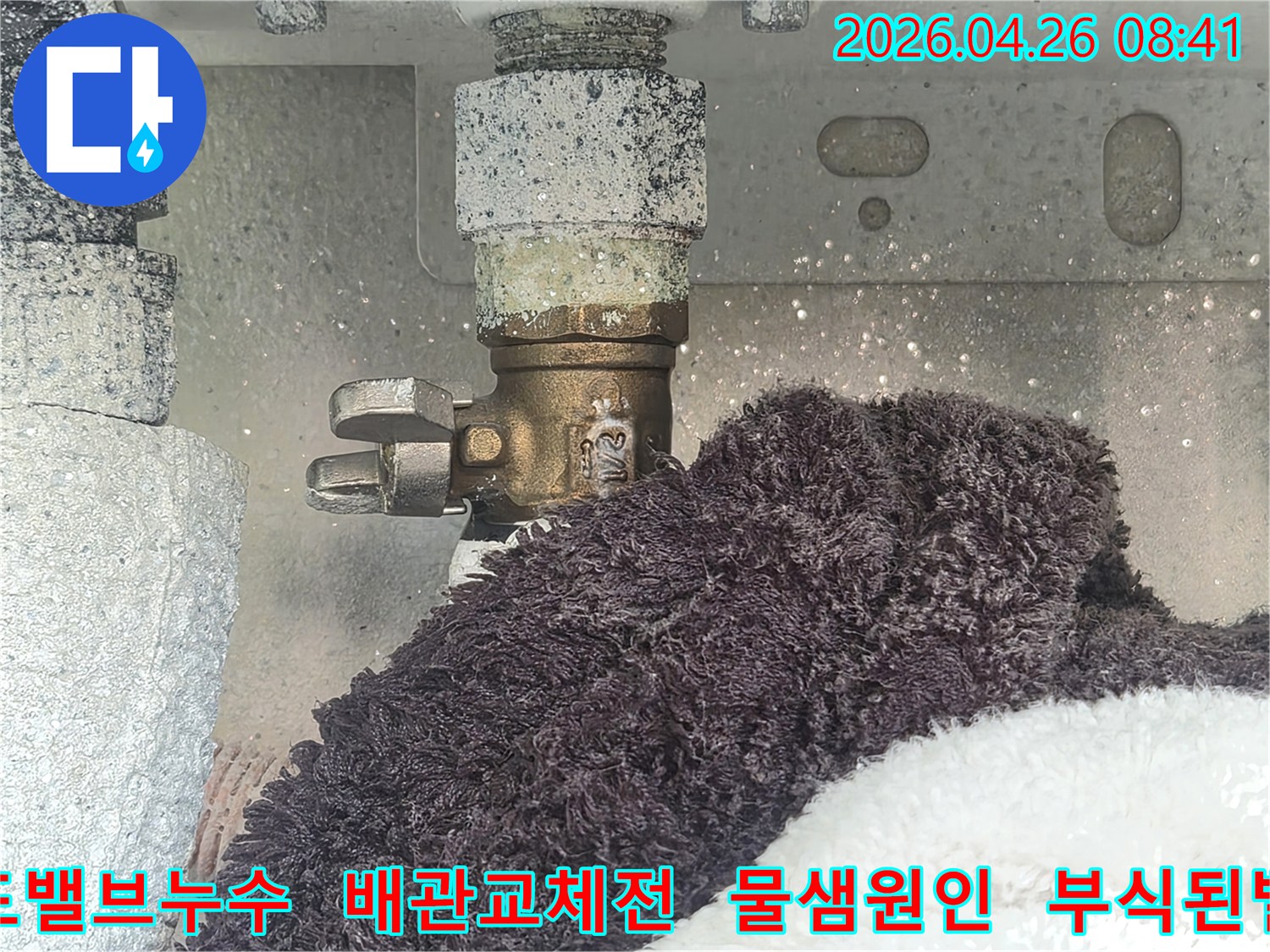 수도 밸브와 연결된 배관 주변에 하얀 부식 물질이 쌓여있고-물이 새는 흔적이 보이는 사진-수리 전 누수 현장을 담고 있습니다