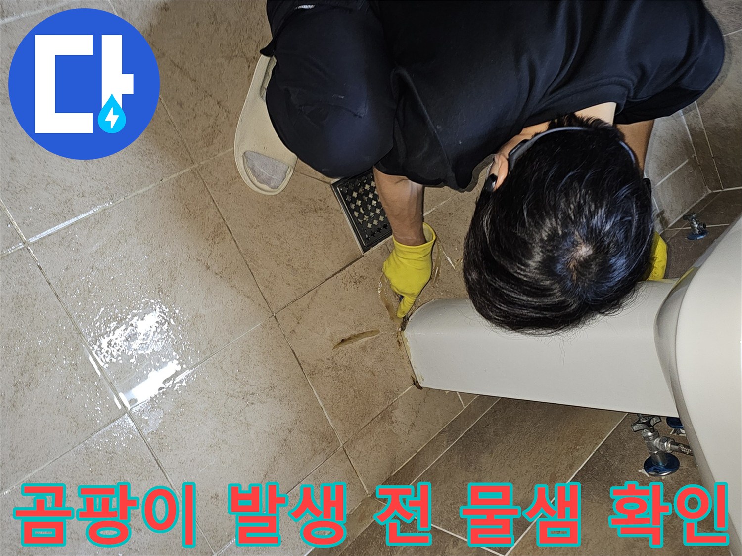 전문 엔지니어가-노란 장갑을 끼고-욕실 바닥의 젖은 타일과-세면대 하단부를-집중적으로 관찰하며-곰팡이 발생 전 물샘을 확인합니다