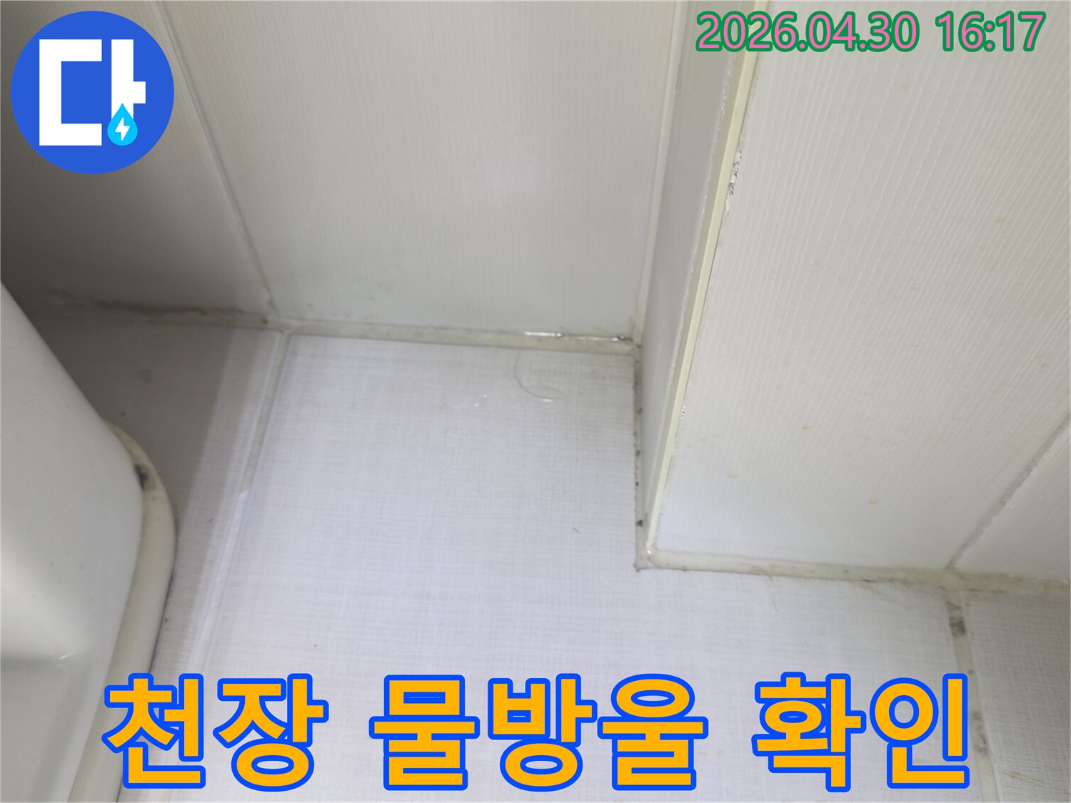 천장과 벽의 경계에서 물방울이 맺히고-벽지가 젖어있는 상태를 보여주는-누수 발생 지점의 클로즈업 사진