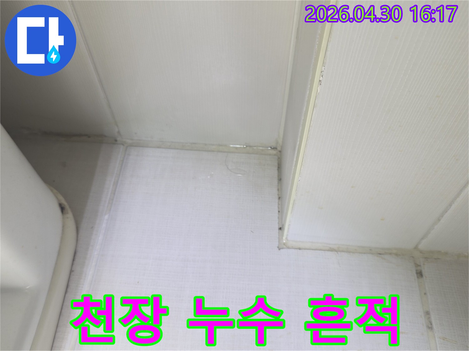 천장과 벽의 경계에서 물이 새어 나와-벽지가 젖어있는 상태를 보여주는-누수 발생 현장의 증거 사진