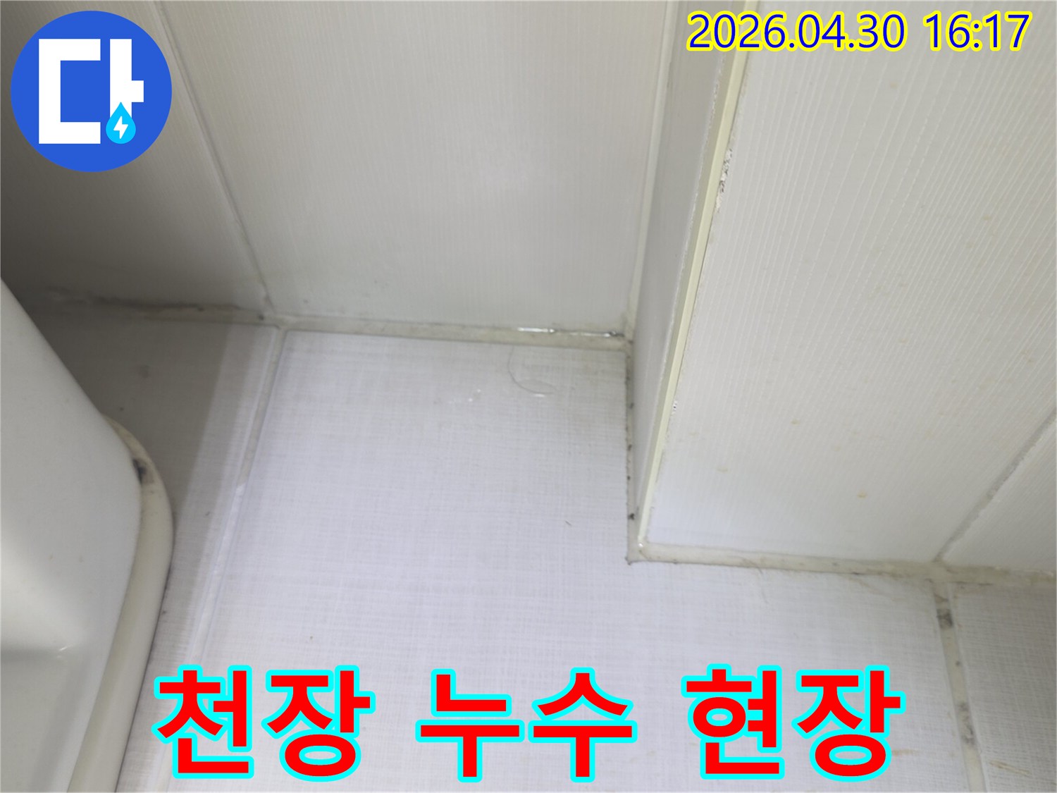 천장과 벽의 경계에서 물이 새어 나와-벽지가 젖어있는 상태를 보여주는-누수 발생 현장의 증거 사진