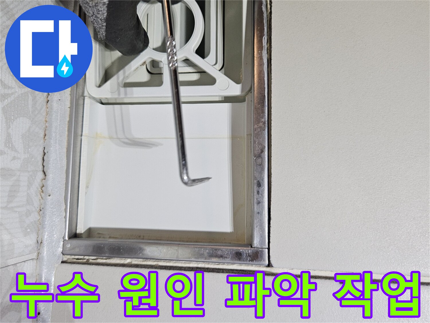누수 전문 기술자가-특수 도구로-벽면 틈새를-정밀하게-조사하며-누수 원인을-파악하는 장면입니다
