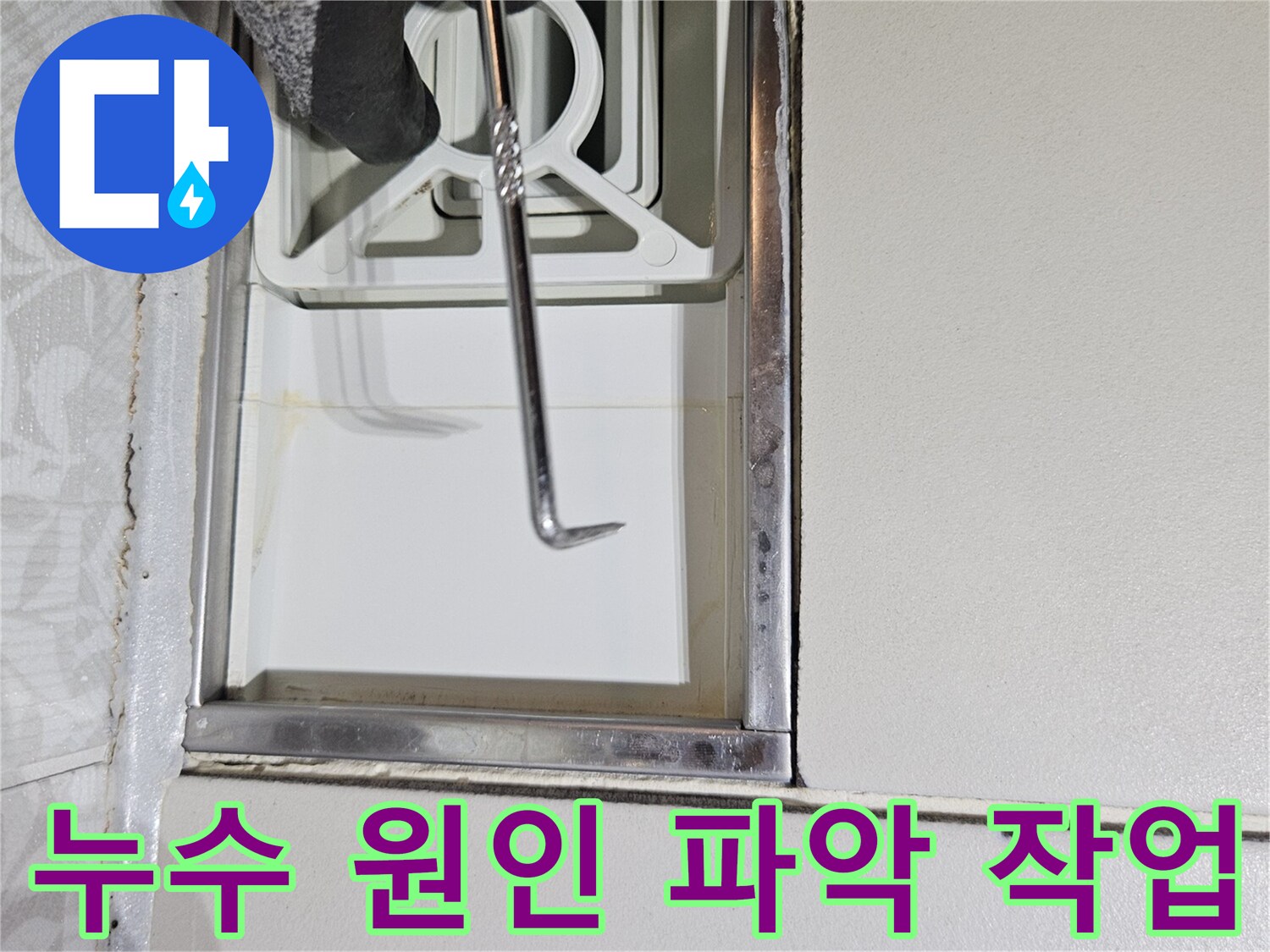 누수 전문 기술자가-특수 도구로-벽면 틈새를-정밀하게-조사하며-누수 원인을-파악하는 장면입니다