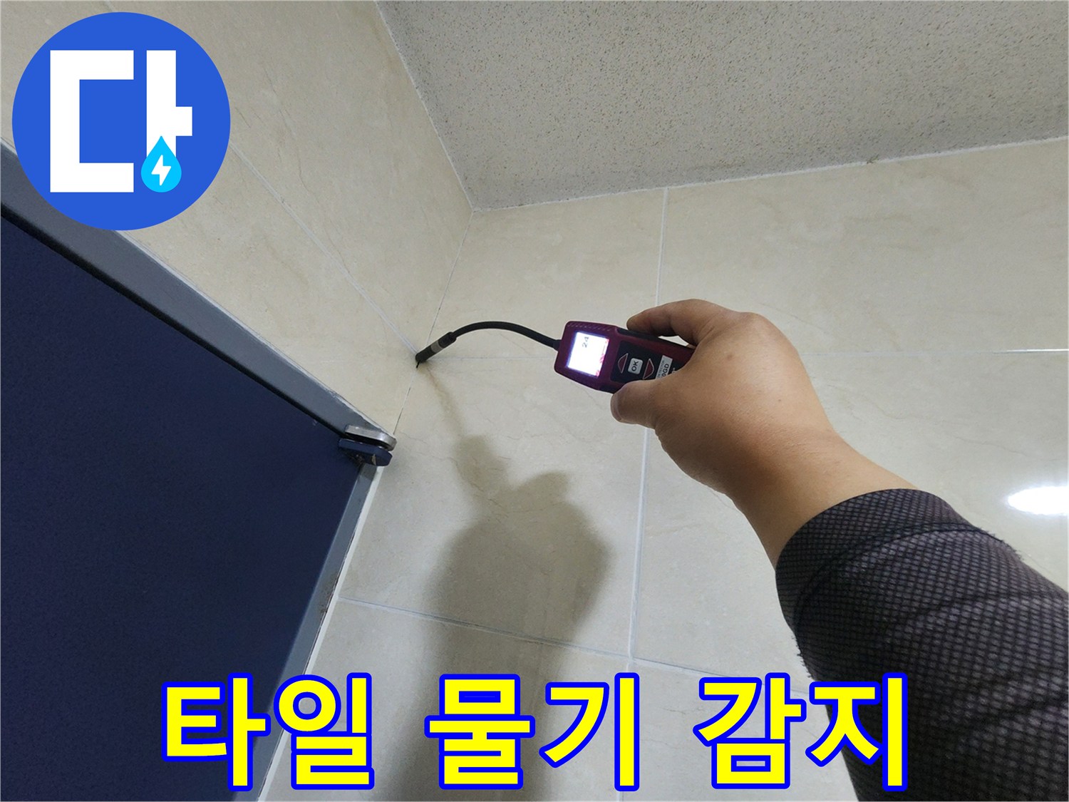 누수 전문 엔지니어가-타일 벽면의 미세한 틈새에서-고성능 탐지기로-숨겨진 물기를 정확히 감지하고 있습니다.