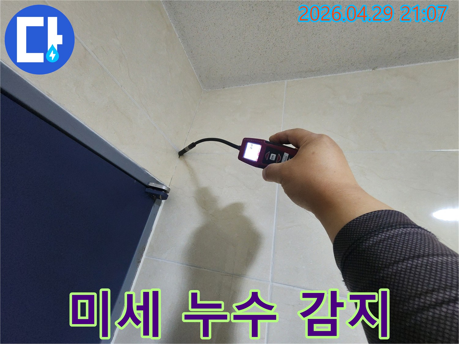 누수 전문가가-고감도 센서가 장착된-탐지 장비로-벽면 내부의 미세한 습기를-정확하게 감지하고 있습니다.