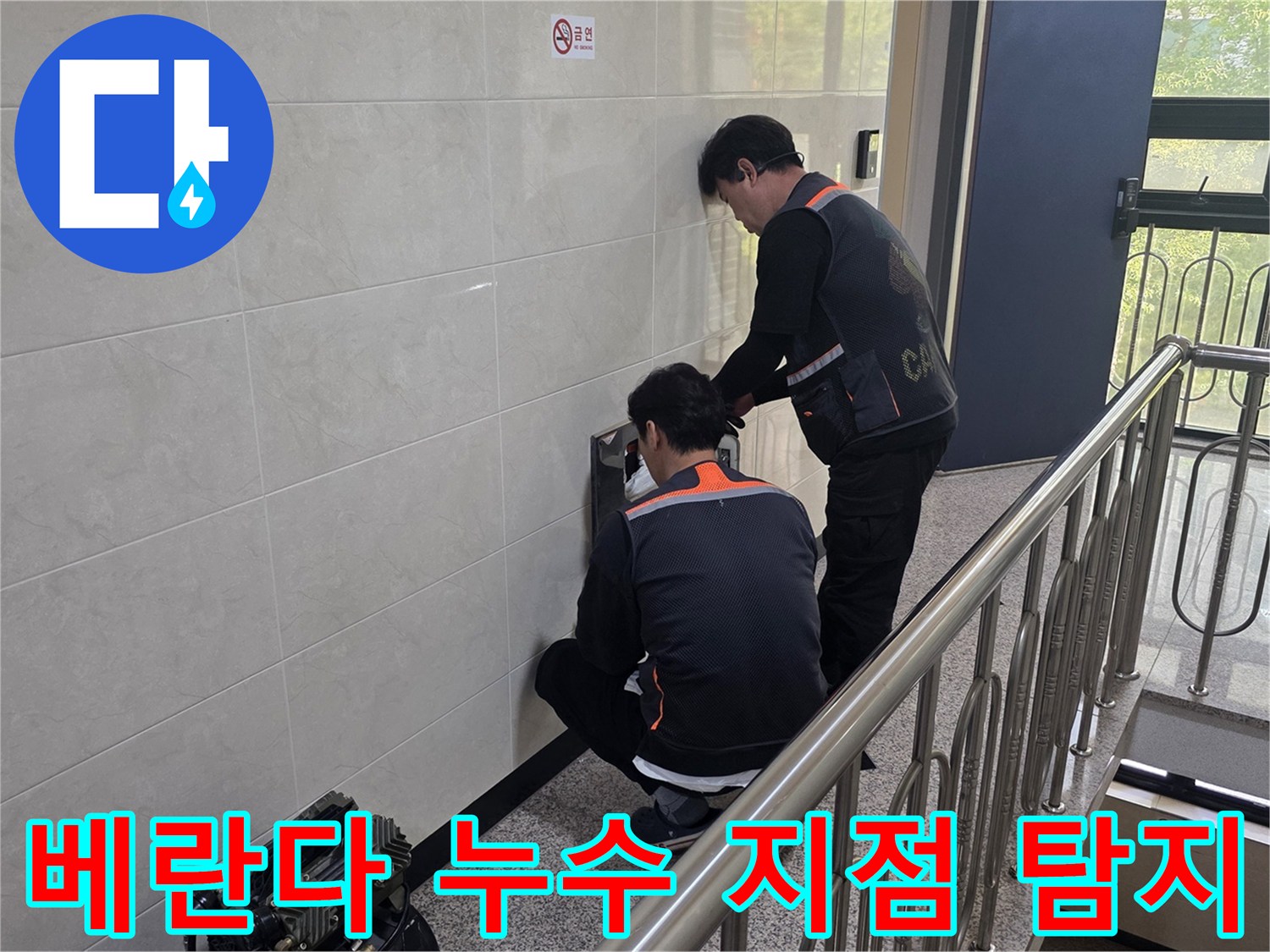 두 명의 전문 기술자가 건물 벽면의 베란다 누수 의심 지점을 정밀하게 탐지하고 있습니다-쾌적한 주거 환경을 위한 정확한 원인 파악 작업입니다.