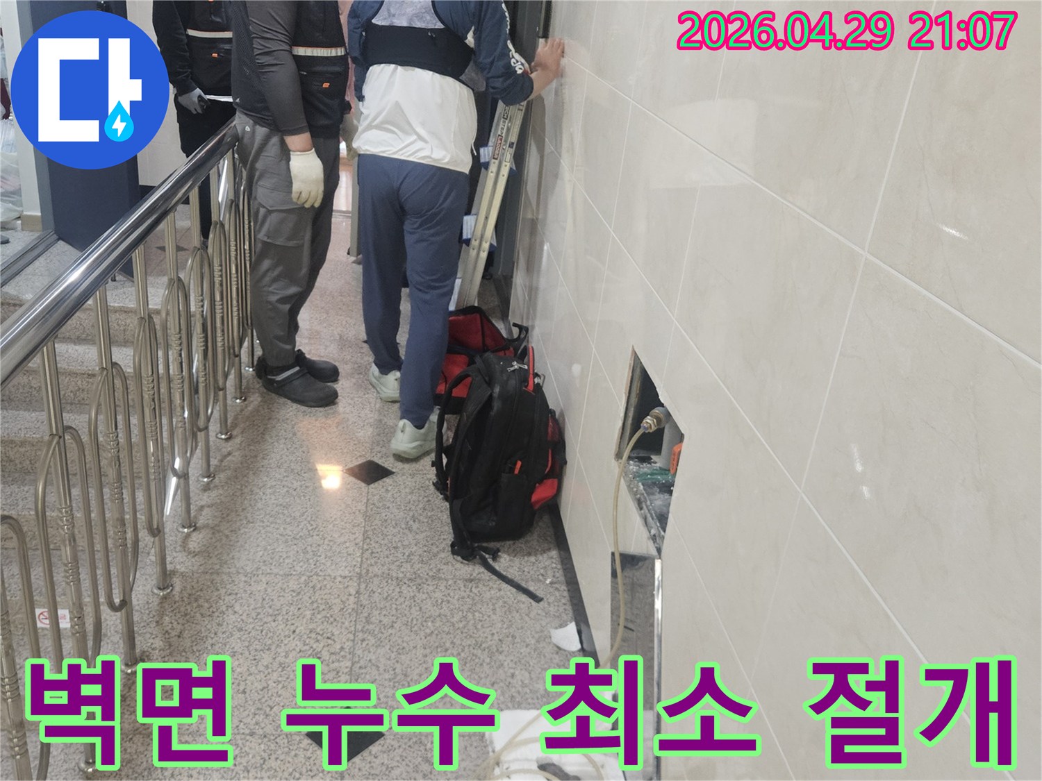 벽면 타일 손상을-최소화하며-누수 지점을-확인하기 위해-조심스럽게-작업하는-전문가의 모습입니다.