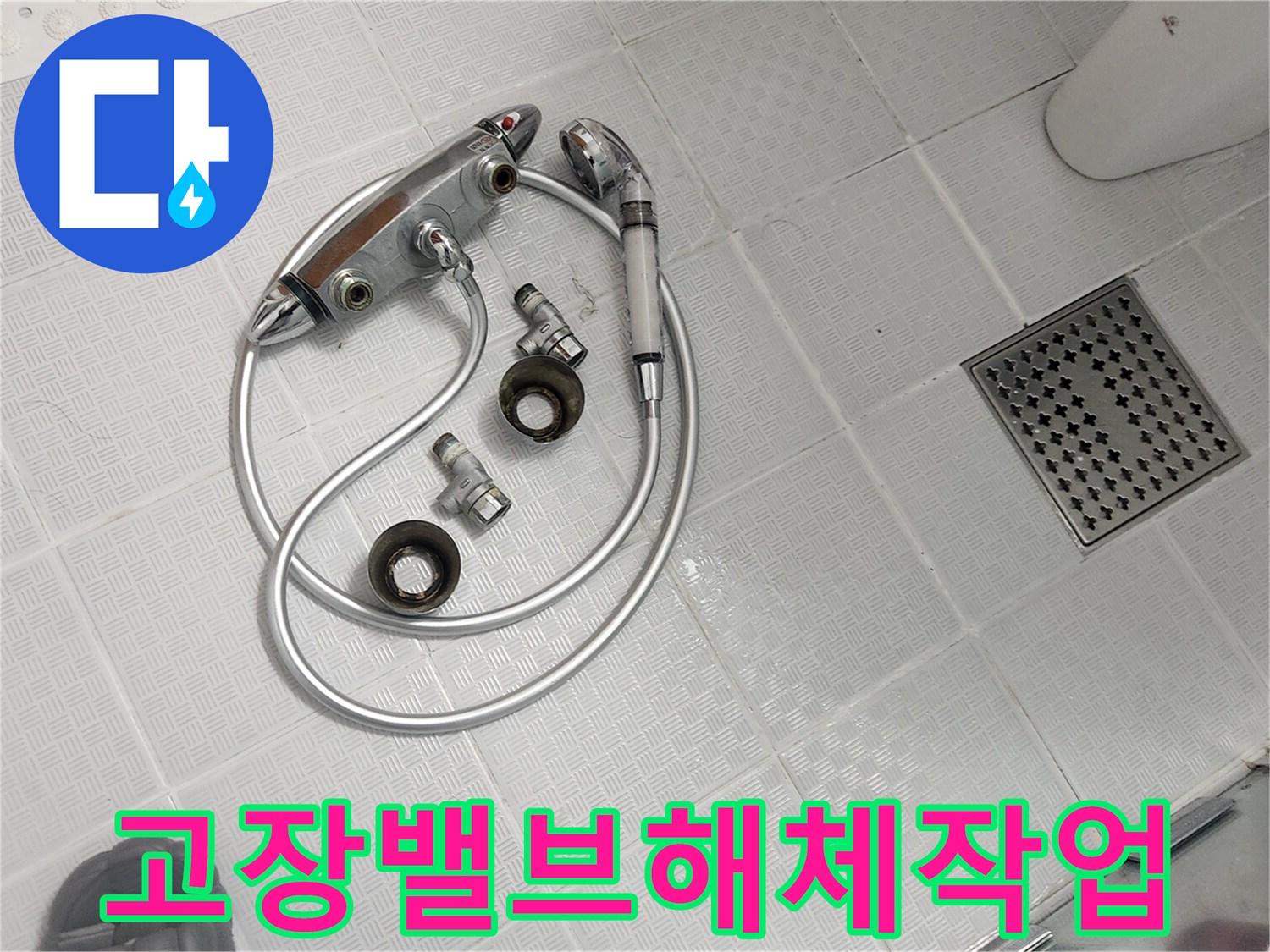 욕실 바닥에 놓인 고장 난 샤워기 밸브와 호스-교체를 위해 분리된 모습