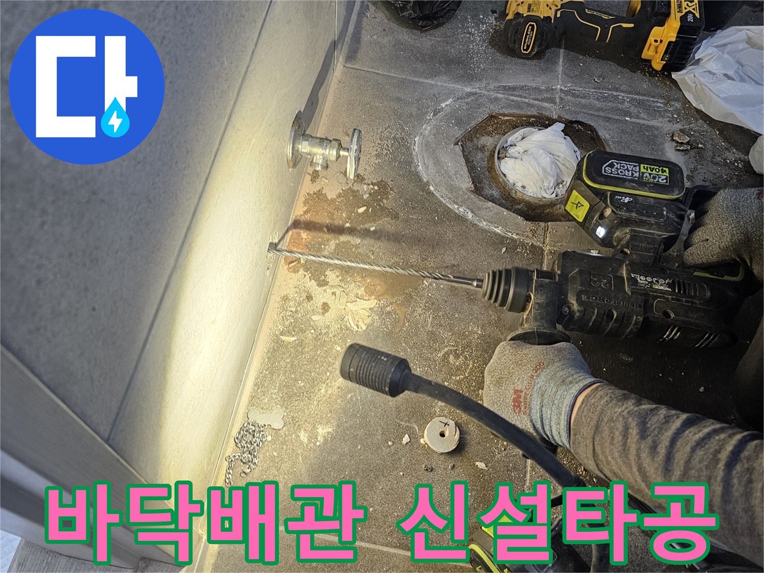 누수 공사 중-새로운 배관을 설치하기 위해 바닥을 타공하는 장면