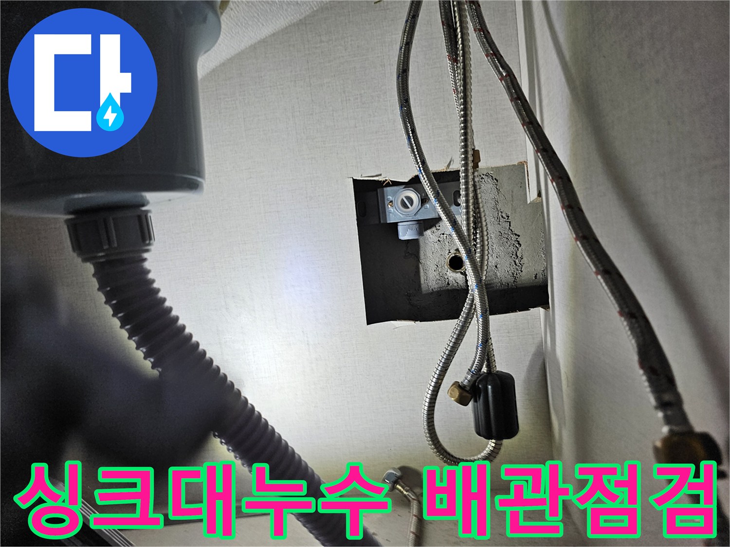 싱크대 하부장 내부에서-배관 연결 부위를-정밀하게 점검하는 모습입니다.