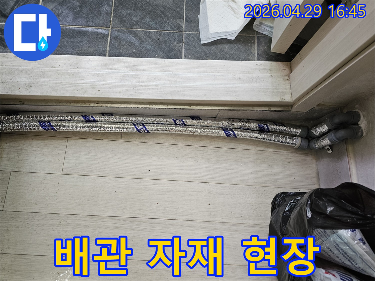 이 이미지는-남양주 진건읍 성심아트빌라-누수 배관 교체 작업을 위해-새로운 배관 자재가-현장에 배치되어 있는-모습을 보여줍니다
